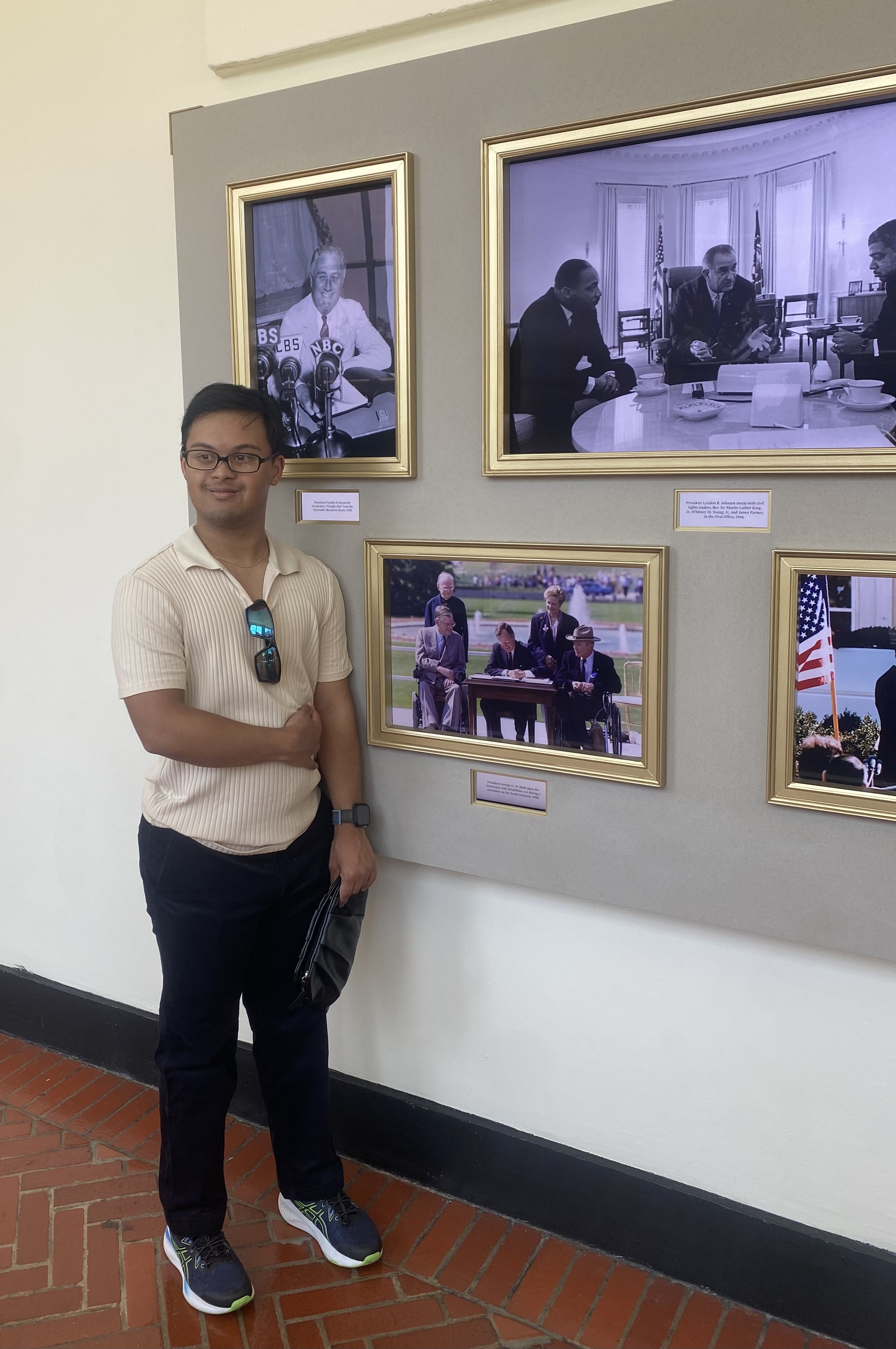 Hari posing with the photo of President George H.W. Bush signing the Americans with Disabilities Act. 