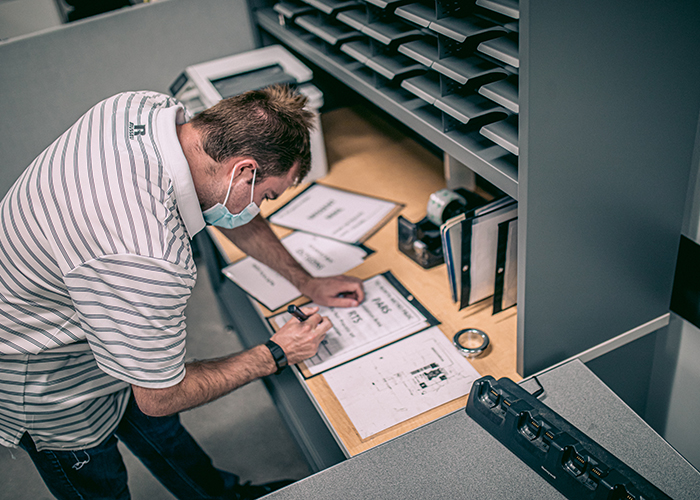A white man bend over a workspace in an office