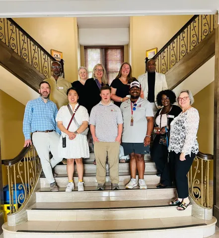 Group of adults standing on a marble staircase
