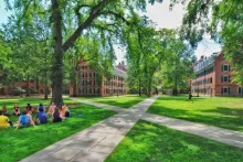 photo of campus quad with students sitting on the grass