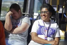 Two young women laughing on a bus.