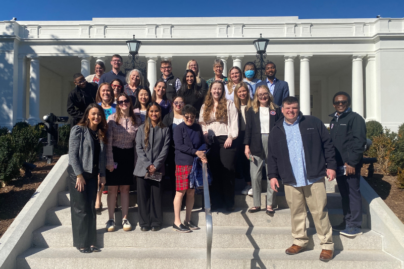 The 2025 TCPA Cohort and staff standing for a photo on steps in front of the White House.