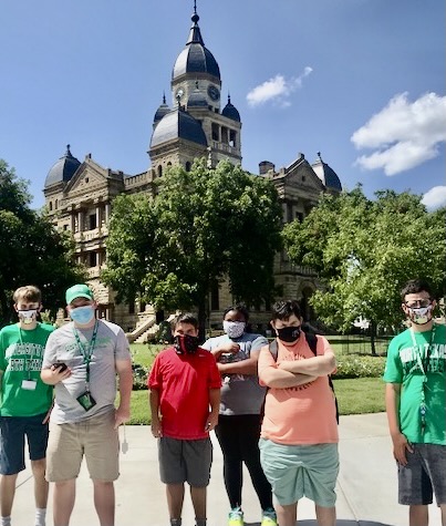six students standing in front of a large university building