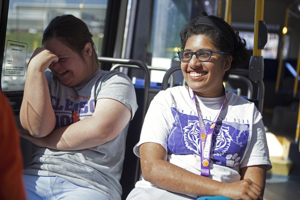Two young women laughing on a bus.