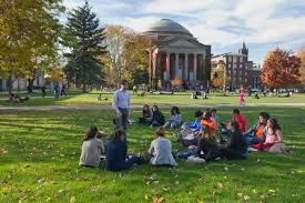 college campus with students sitting on lawn